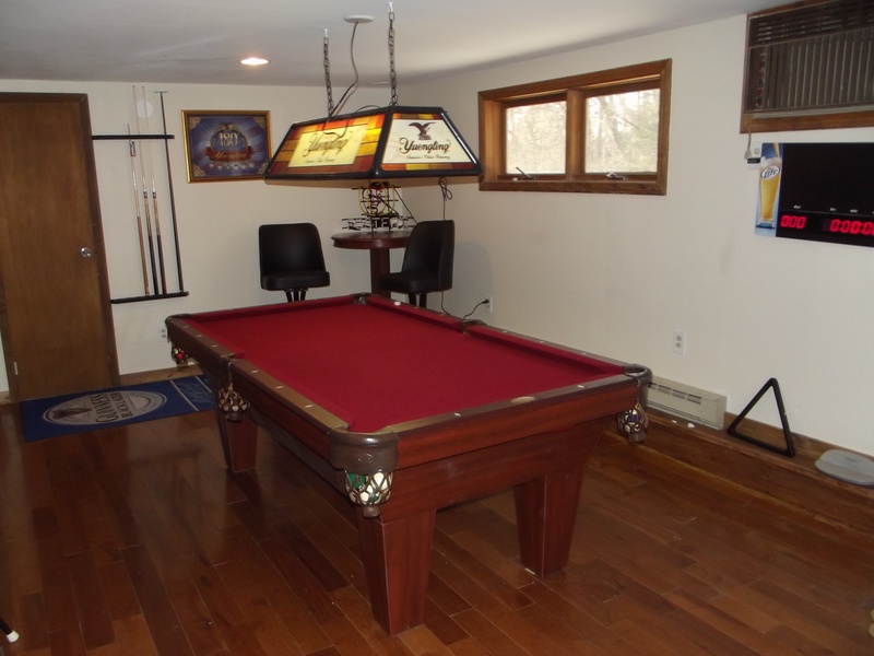 A pool table in a room with hardwood floors.
