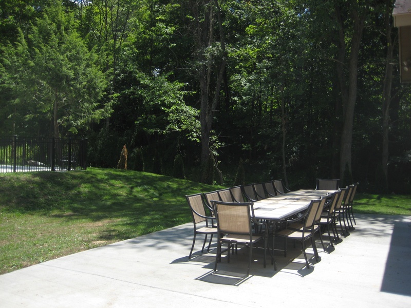 A concrete patio with a table and chairs.