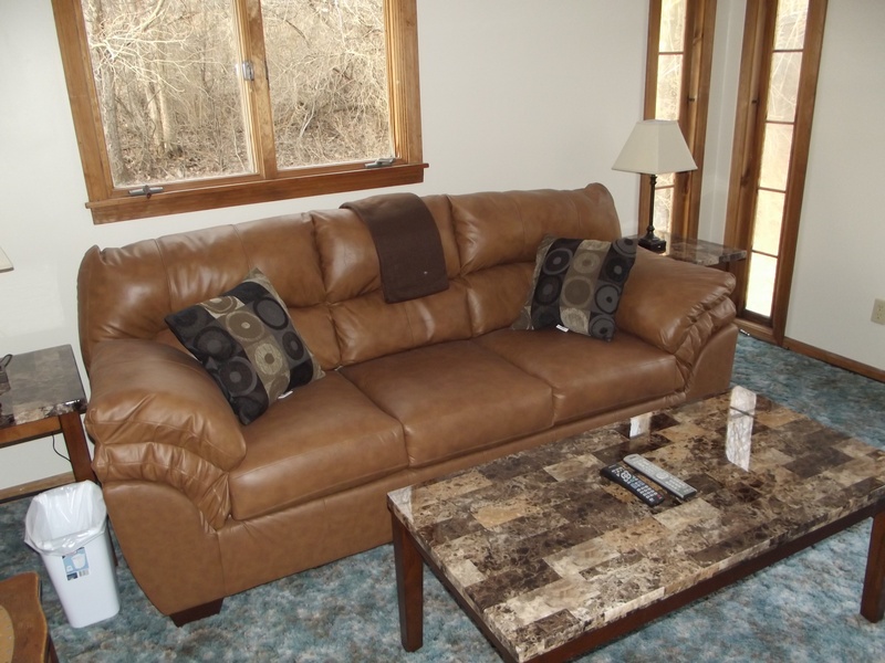 A living room with a brown couch and coffee table.