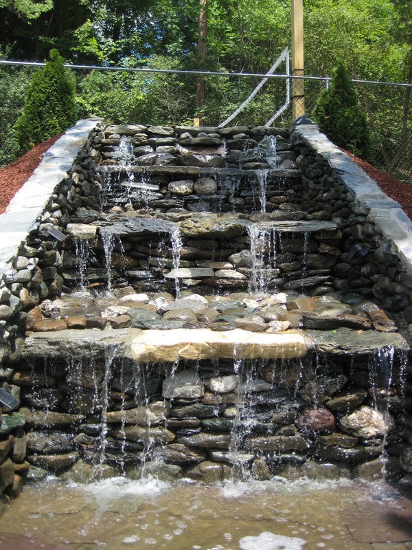A stone waterfall with steps leading up to it.