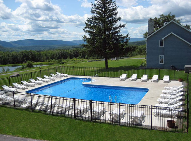 A large swimming pool in front of a house.