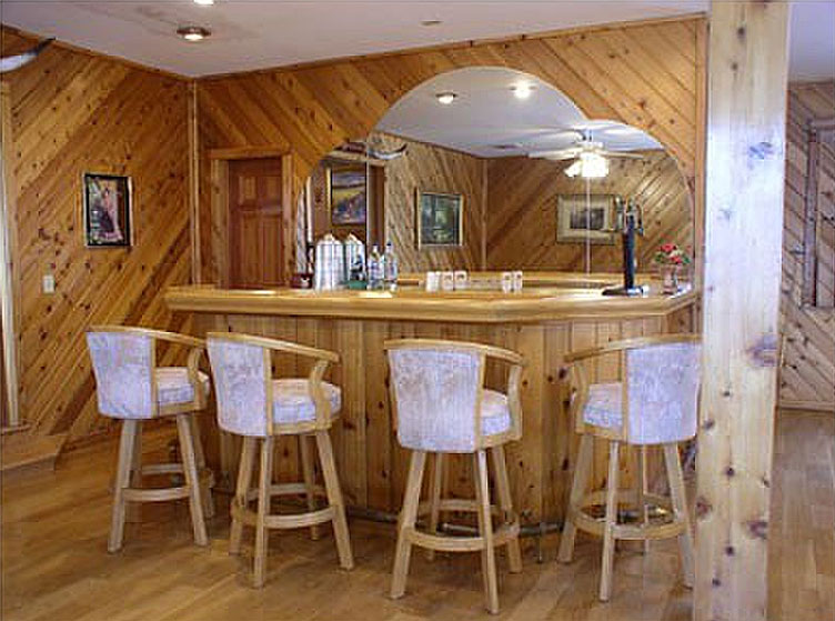 A bar in a home with wood paneling.