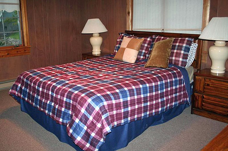 A plaid comforter on a bed.