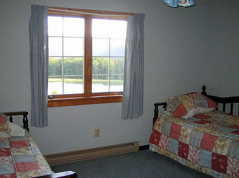 Two twin beds in a room with a window.