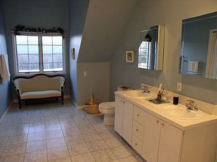 A bathroom with two sinks and a window.