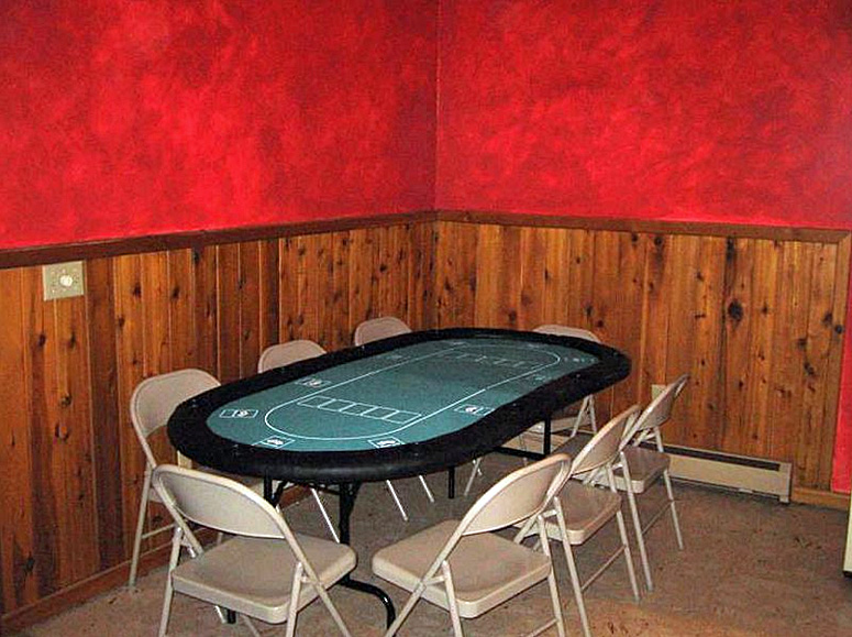 A poker table in a room with red walls.