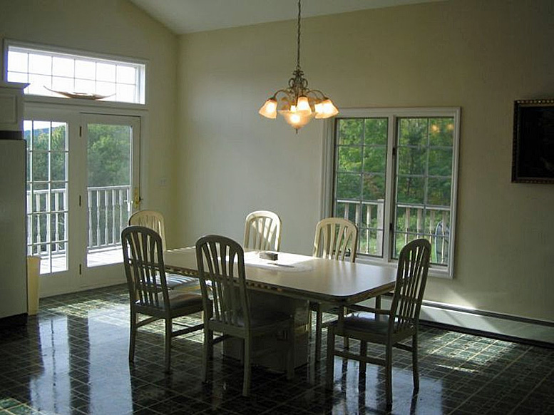 A dining room with a table and chairs.