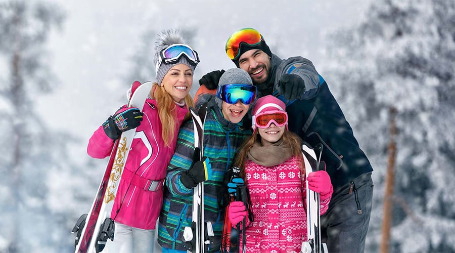 A family with skis posing for a picture.