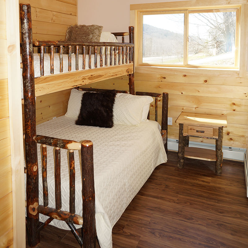 A bunk bed in a room with wooden walls.