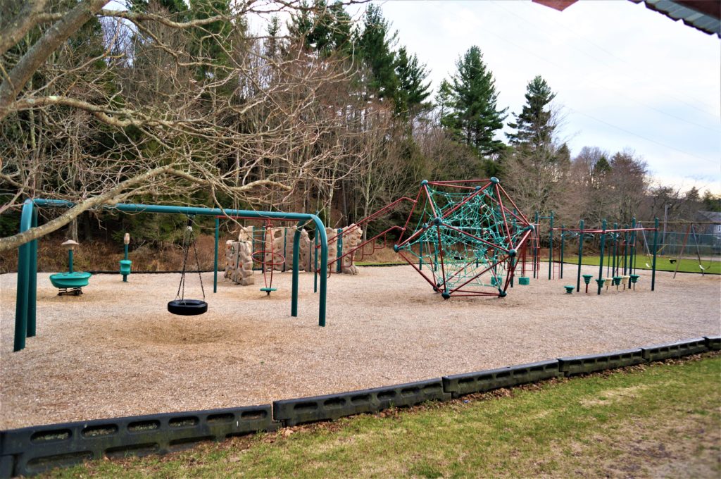 A playground with swings and a slide.