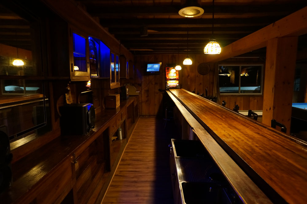A bar with a long wooden bar top.