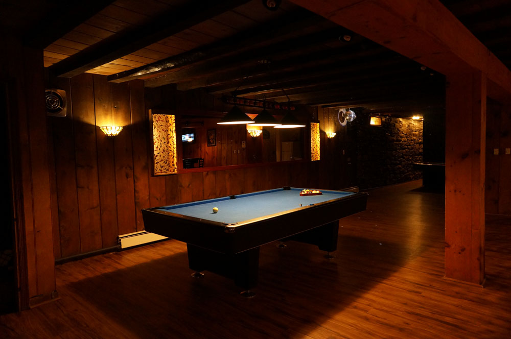 A pool table in a dark room.