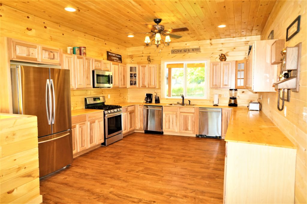 A kitchen in a log cabin with wood floors.