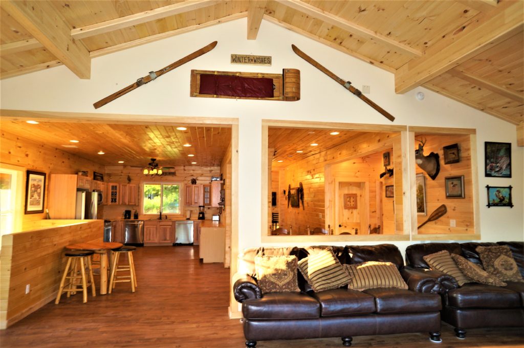 A living room with skis hanging from the ceiling.