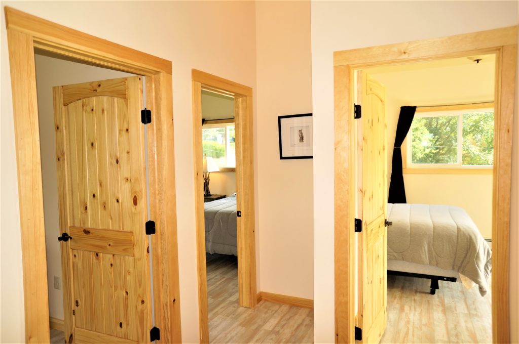 Two wooden doors leading into a bedroom.