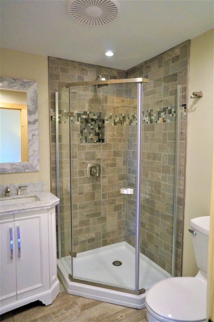 A bathroom with a glass shower stall and toilet.