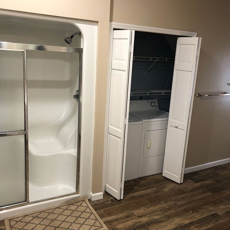 A bathroom with a shower and a washer and dryer.