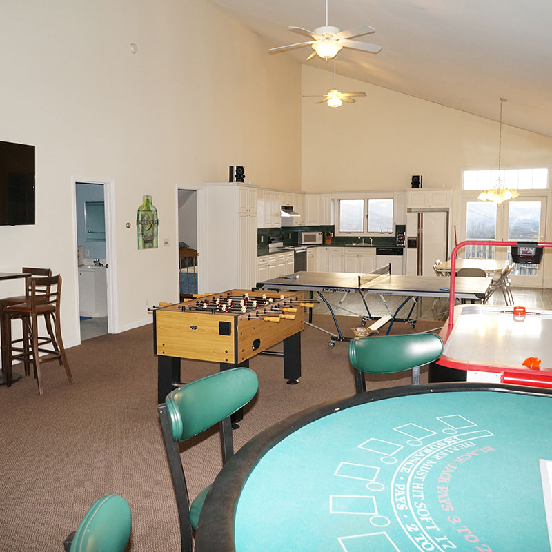 A living room with a pool table and a ping pong table.