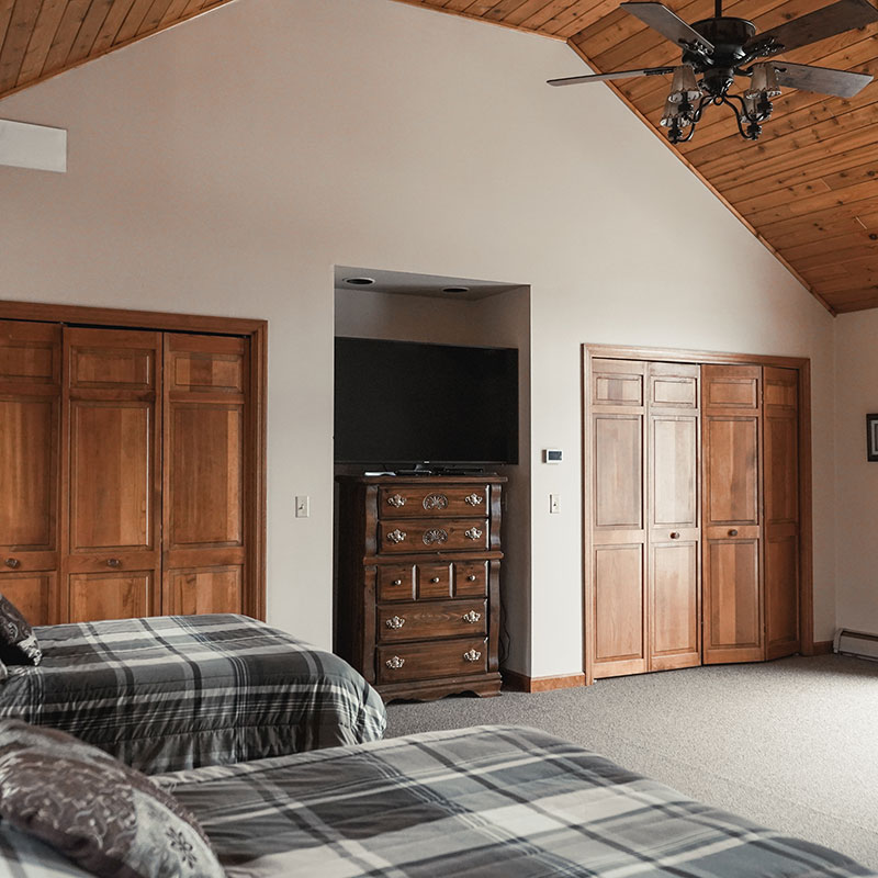 A bedroom with two beds and a ceiling fan.