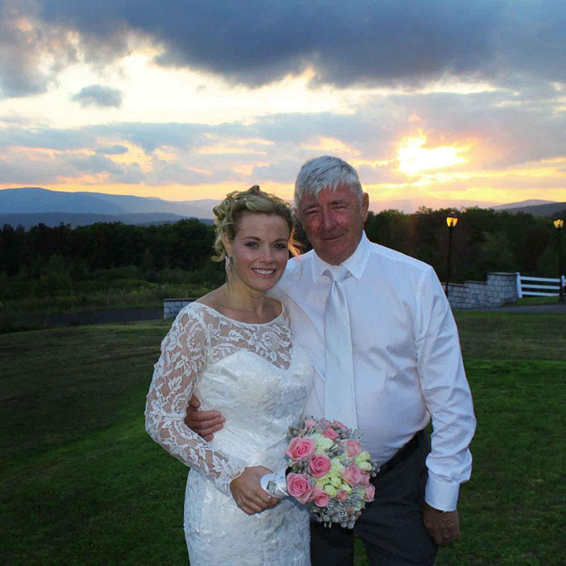 A bride and groom posing for a picture at sunset.