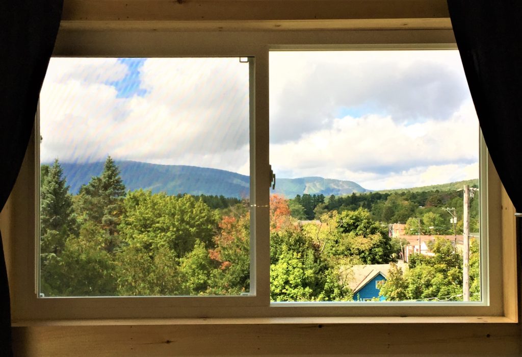 A view of mountains from a window in a room.