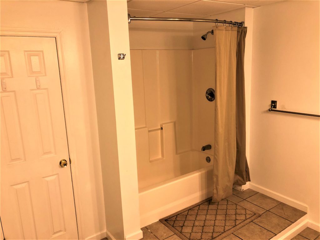 A small bathroom with a shower and toilet.