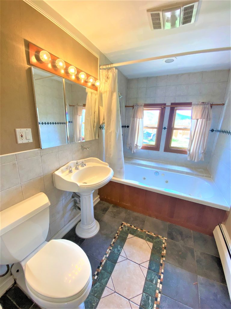 A bathroom with a tub, sink and toilet.