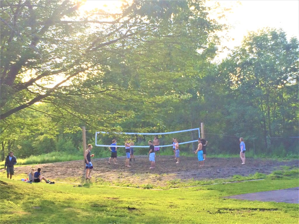 A group of young people playing volleyball outdoors