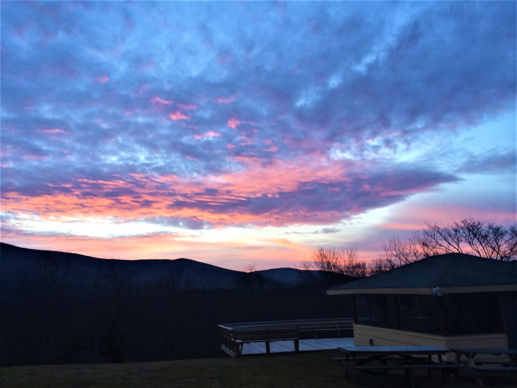 A colorful sunset over a picnic table in the mountains.