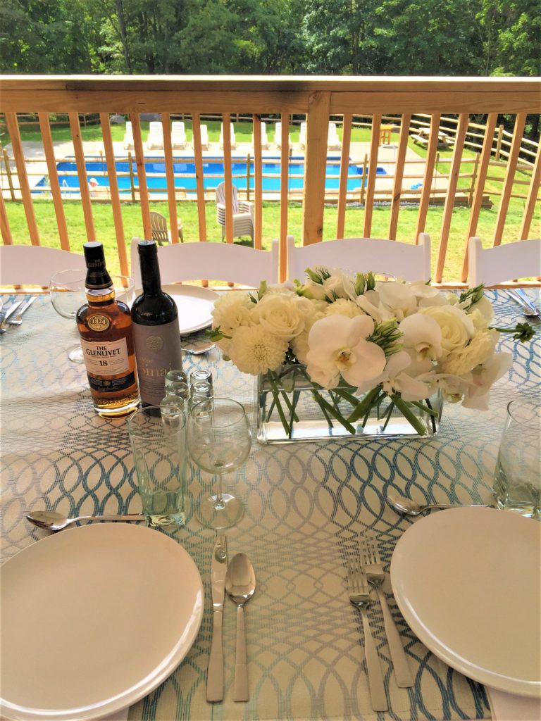 A close-up of a table arrangement with floral centerpiece and some liquor