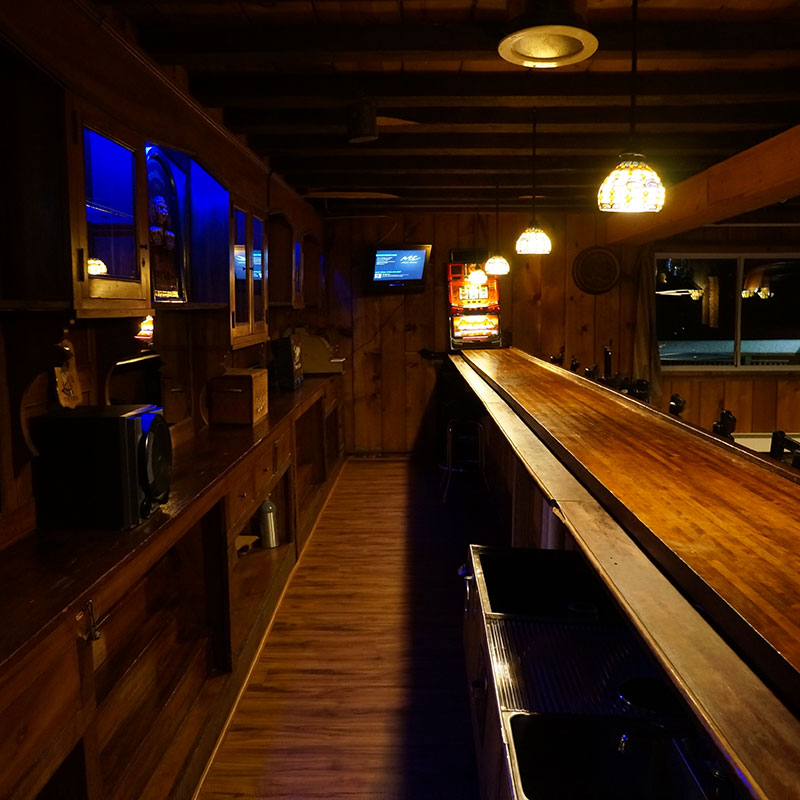 A bar with a long wooden bar top.