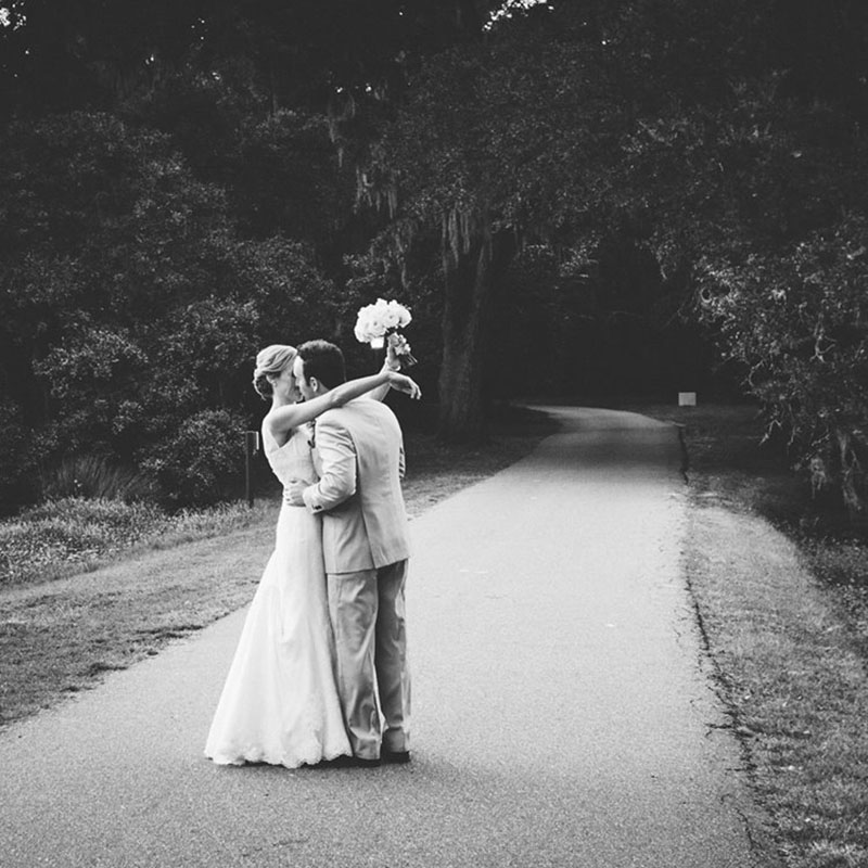 Black and white image of a newly married couple kissing together