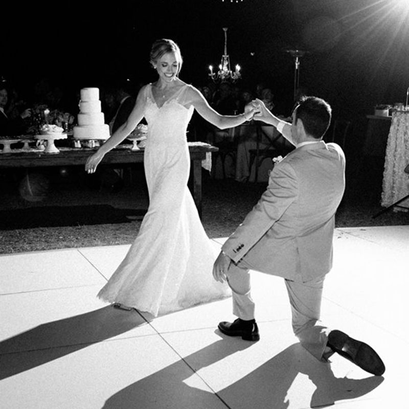 Black and white image of a man dancing with her bride