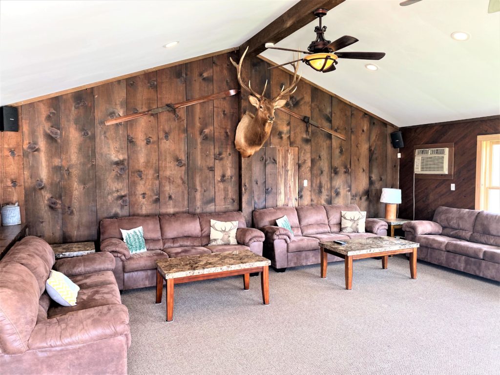 A living room with a deer head on the wall.