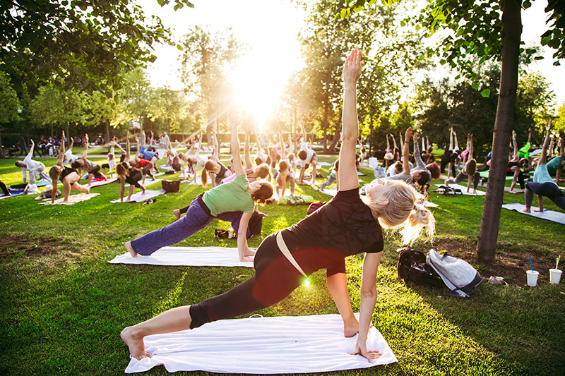 A group of people doing yoga in a park.