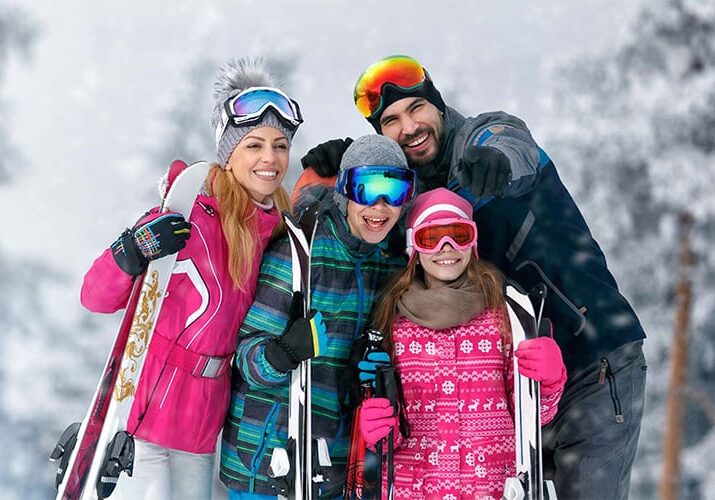 A family with skis posing for a picture.