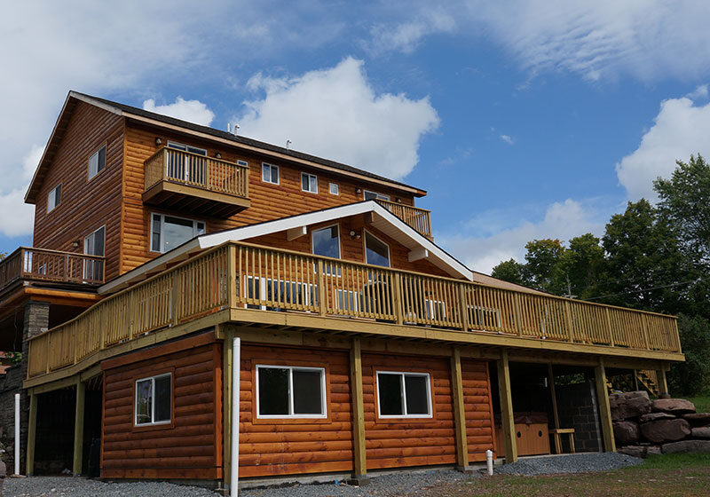 A large wooden house with a deck.